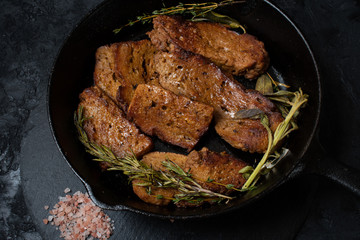 Roasted seitan in cast iron pan with various herbs and spices
