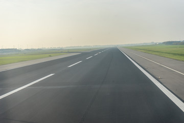 Fototapeta na wymiar Amsterdam Schiphol,, a highway with cars parked on the side of a road airport runway