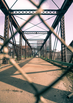 Chain-linked fence looking at the Old Northern Ave Bridge in Boston, MA.