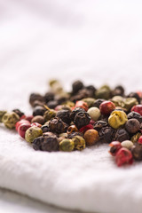 Pile of peppercorns on a white cloth napkin.