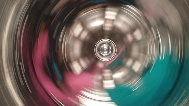 Stainless steel washing machine drum turning spin cycle washing clothing, futuristic industrial look of modern machinery