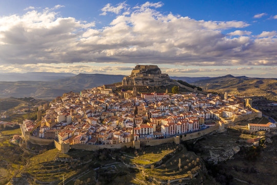 Aerial winter afternoon view of walled medieval Morella with crenelated towers in Central Spain
