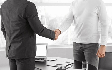 Fototapeta premium Bank manager and man shaking hands in office
