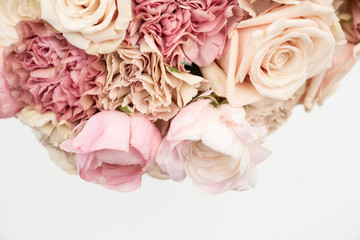 Cream and blush roses and carnations in a fresh flower bouquet on white background