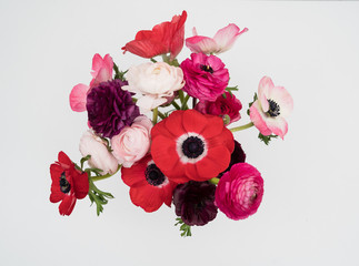 Pink blush and maroon ranunculus and anemone flowers flat lay