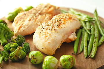 Cooked chicken fillet with vegetables on board