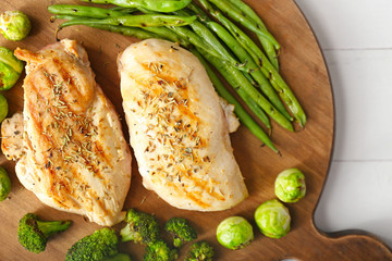 Cooked chicken fillet with vegetables on board