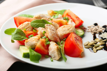 Plate with tasty chicken salad on table, closeup
