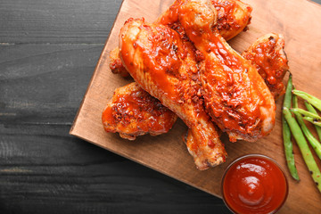 Cooked chicken drumsticks with tomato sauce on table