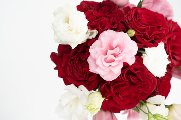 Red roses and pink and white blooms on white background