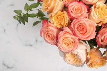 Blush and pink rose bouquet flat lay on marble background