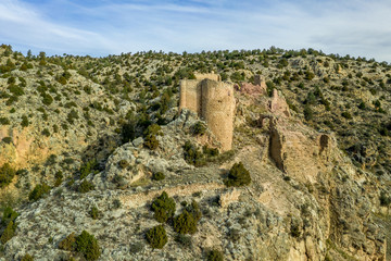 Fototapeta na wymiar Aerial view of Santa Croche (Saint Cross) medieval castle ruin on the road to Albarracin Spain on a steep crag with a semi circular donjon and partially ruined embrasure 
