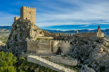 Fototapeta na wymiar Aerial view of medieval restored Sax castle with two rectangular towers and two semi circular towers protecting the gate near Alicante Spain