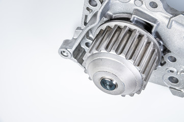 Close-up New metal automobile pump for cooling the engine of a water pump on a gray background. The concept of new spare parts for the car engine