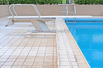 Outdoor private recreational swimming pool with staircase, diving platform