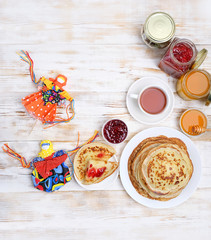 Pancake week, Maslenitsa concept. folk traditional toy doll Maslenitsa, Pancakes, Cup of tea, teapot and sweets - honey, jam on wooden table. 