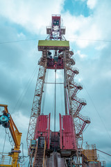 Oil and Gas Drilling Rig onshore dessert with dramatic cloudscape. Oil drilling rig operation on the oil platform in oil and gas industry