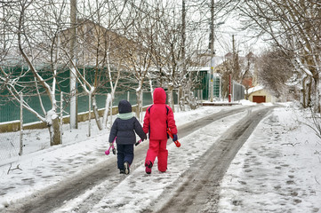 Fototapeta na wymiar Children in warm clothes on a walk on a cold winter day