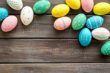 Colorful Easter eggs frame on dark wooden background top-down copy space