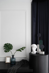 Bedroom working corner decorated with artificial plant in glass vase and decorated minimal sculpture in modern classic style/ interior design / navy blue blanket