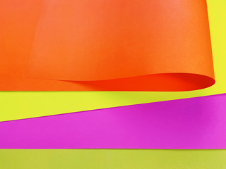 Multicolour paper sheets textured background with curve like a wave, close up. Abstract background with copy space.