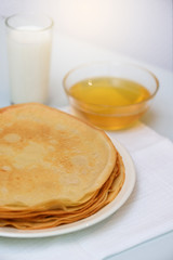 Shrovetide, Shrovetide week in February. pancakes on a plate with honey, milk and sour cream. on a light background, vertical photo