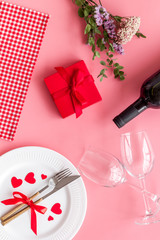 Romantic dinner on Valentines Day. Wine, plate, present box on white background top-down
