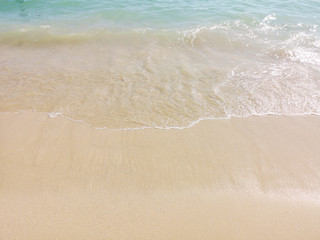 Fototapeta na wymiar White sand and water on the seashore as a background