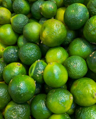 Green limes on the market as a background