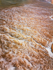 Golden sand and water on the seashore as a background