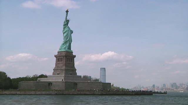 Breathtaking view of the iconic Statue of Liberty in New York city from a ferry. Tracking shot, Long shot.