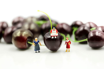 Miniature people : housekeeper with cherrys,cherry month concept.