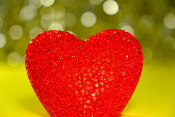 Red heart shape on a yellow shiny background. Concept of love emotions