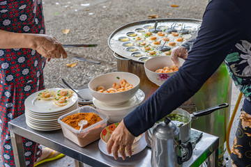 Vietnamese hawker making crispy shrimp pancake at street vendor