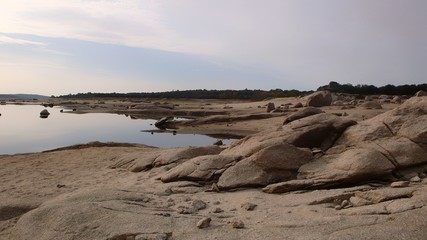 EMPTY WATER LAKE NEXT TO DRY SHORE BY DROUGHT. CLIMATE CHANGE