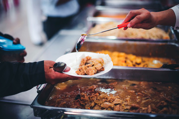 The hands of the poor apply for food from rich people who donate food.