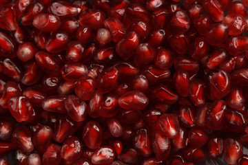 Pomegranate seeds with water drops. Texture for the background. Ripe berries of pomegranate. Red texture of the granules in the macro.