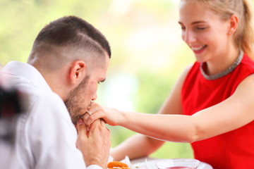 Man kissing his girlfriend's hand after proposing her on the luxury dinner date in valentine day