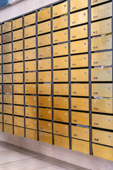 Vertical photo of metallic mailboxes in condominium lobby