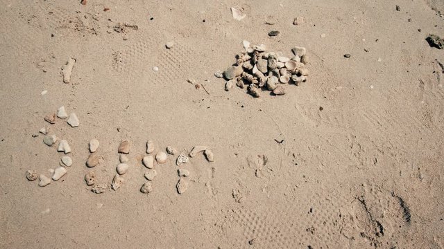 Hyperlapse, pebbling the word SUMMER on the sand