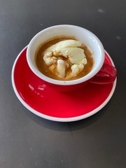 red cup of espresso coffee with vanila icecream on black table background.