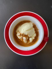 red cup of espresso coffee with vanila icecream on black table background.