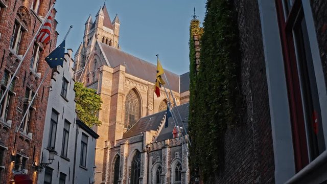 Belgium, Bruges: majestic view of St. Salvator's Cathedral with flags on houses