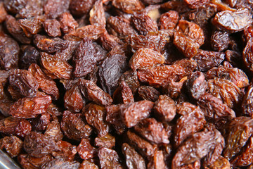 black raisins in the wooden bowl. Sweet dry raisins close-up shot for background . Many Raisins for background grape raisin texture .