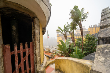 Extremely heavy, thick fog at the colorful Pena Palace in the winter, as tourists walk around the castle steps