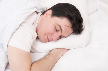 Brunette man sleeping in bed