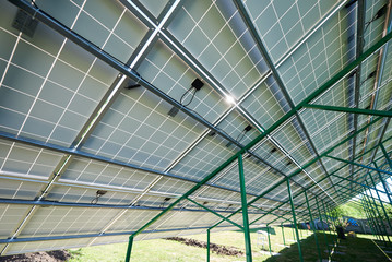 Green metallic carcass maintaining solar batteries. smart exterior, using renewable sun energy. Ecological friendly, nature saving, economical. Innovative high-tech technologies. Renewable resources.