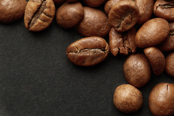 Roasted coffee beans isolated in dark  background. Espresso dark, aroma, black caffeine drink.