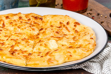 Caucasian dish khachapuri with egg served on a white plate