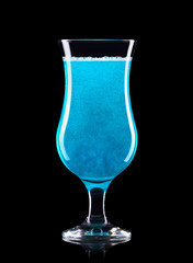 Blue curacao cocktail in hurricane glass isolated on black background